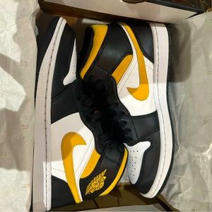 Black, yellow,and white Jordan 1’s.